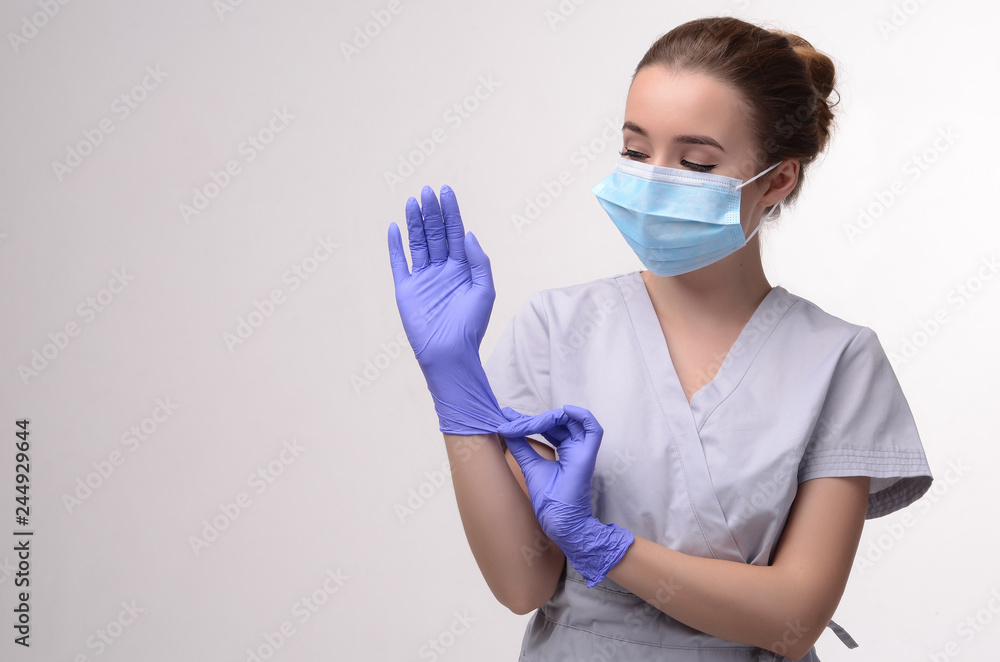 Beautiful female doctor or nurse wearing protective mask and latex