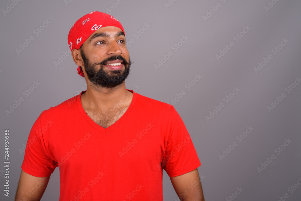 Portrait of young handsome Indian man thinking