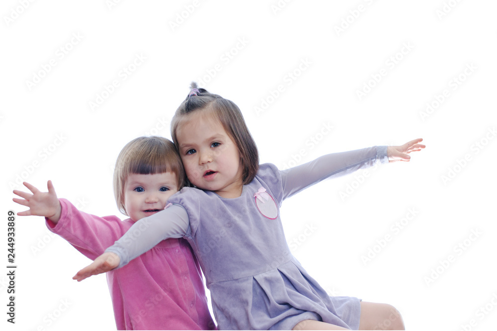 Happy smiling two little girls flying isolated on white background. sibling with different age emotional playing Happy smiling two little girls flying isolated on white background. sibling with different age emotional playing