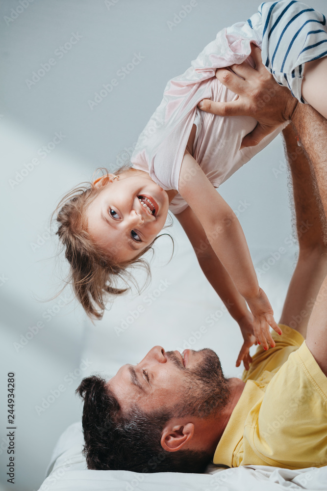 Father and daughter playing on bed Father and daughter playing on bed