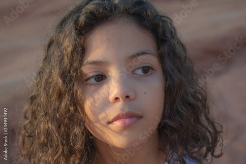 portrait of a cute little girl looking sideways under sunset light