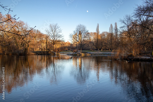Teich im Park mit Romantischen Brücken,Kirche im Winter in Leipzig mit blauen Himmel