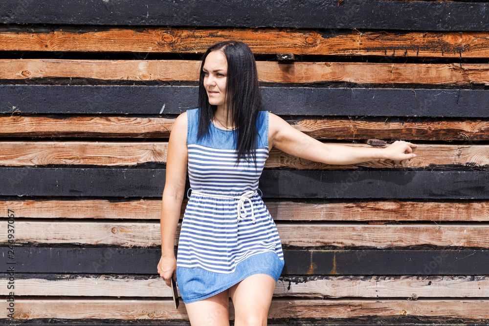Obraz premium adult girl in a striped dress on wood background