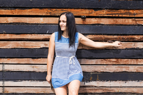 adult girl in a striped dress on wood background