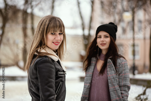 Two young trendy women in snowy winter park