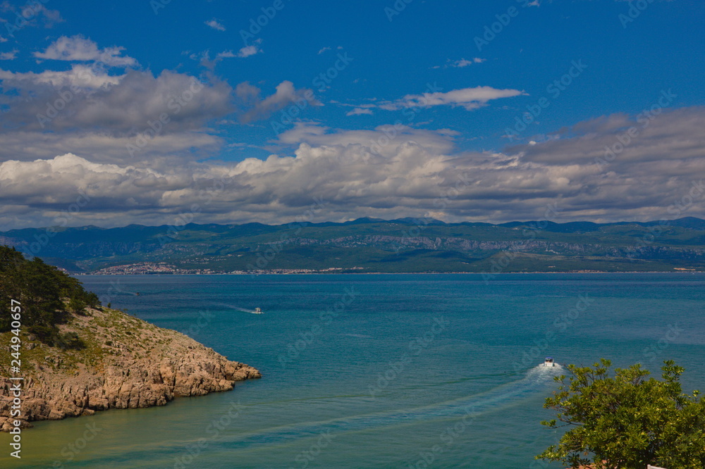 Scenic view from the island Krk towards the croatian mainland with clouds and a blue sky