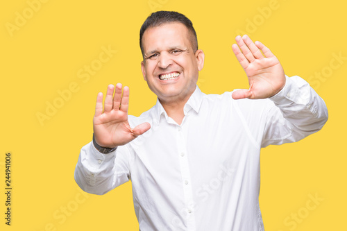Middle age arab elegant man over isolated background Smiling doing frame using hands palms and fingers, camera perspective © Krakenimages.com