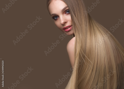 Beautiful blond girl with a perfectly smooth hair, classic make-up. Beauty face