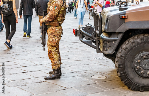 italian military police in full uniform and armed at the busy city street photo