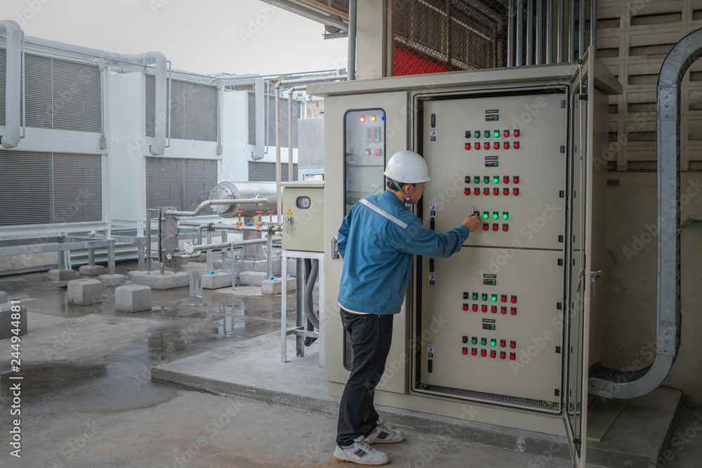 Foto Stock Young engineer checking temperature of refrigeration and