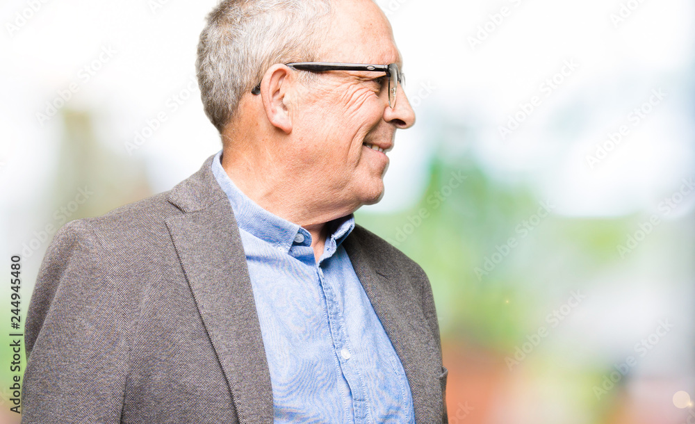 Handsome senior businesss man wearing glasses looking away to side with smile on face, natural expression. Laughing confident. Handsome senior businesss man wearing glasses looking away to side with smile on face, natural expression. Laughing confident.