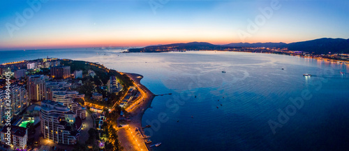 Gelendzhik embankment in the evening twilight from a bird's-eye view. The lights of the promenade are reflected in the smooth water of the Bay. Visible buildings of hotels and boarding houses.  © Александр Трихонюк