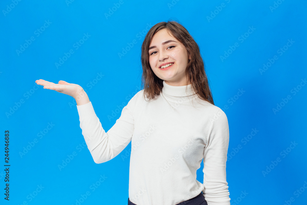Fototapeta premium Young beautiful girl isolated on blue background