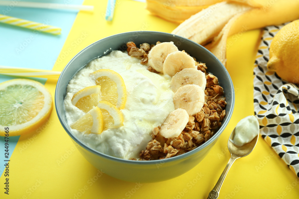 Tasty granola with yogurt and fruits in bowl on color background Tasty granola with yogurt and fruits in bowl on color background