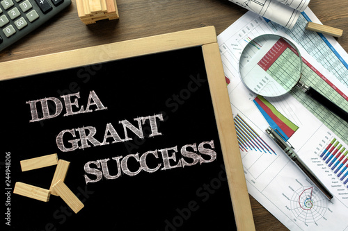 Text Idea, Grant, Success on the blackboard on the desk with office business accessories