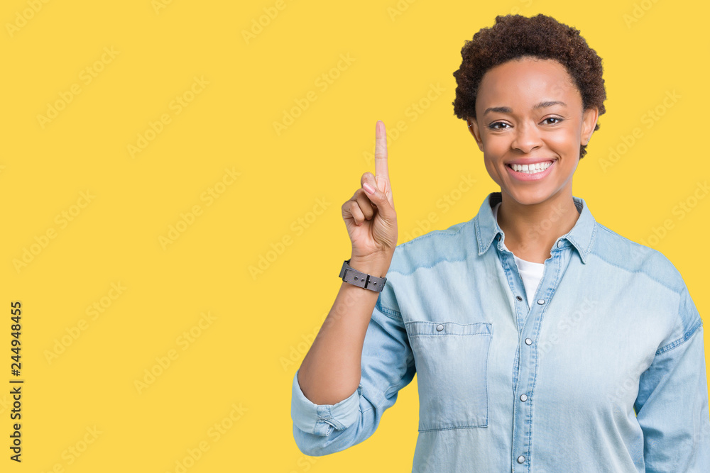 Young beautiful african american woman over isolated background showing and pointing up with finger number one while smiling confident and happy. Young beautiful african american woman over isolated background showing and pointing up with finger number one while smiling confident and happy.