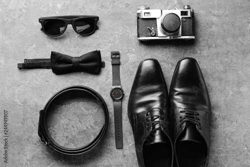 Stylish male accessories with photo camera on grey background