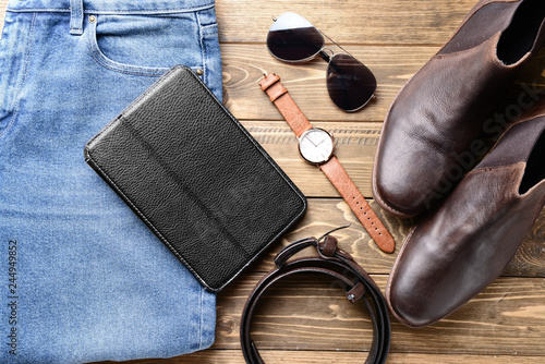 Stylish male clothes with accessories on wooden table