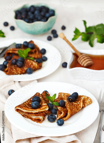 Homemade crepes with fresh blueberries and honey