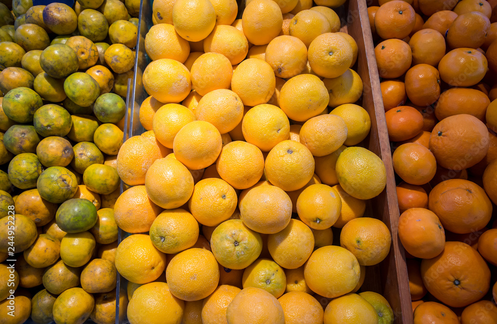 Many fresh and beautiful Oranges with a good taste in the basket at the market. Many orange put on shelves in the market. Fruits and vegetables on display in a supermarket. Food store. Many fresh and beautiful Oranges with a good taste in the basket at the market. Many orange put on shelves in the market. Fruits and vegetables on display in a supermarket. Food store.