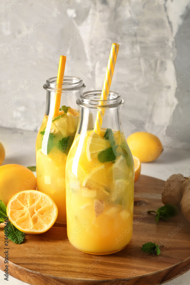Fototapeta premium Bottles of healthy juice with ingredients on wooden board