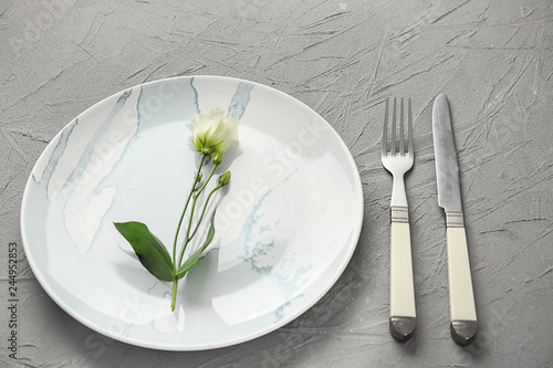 Table setting with floral decor on grey background