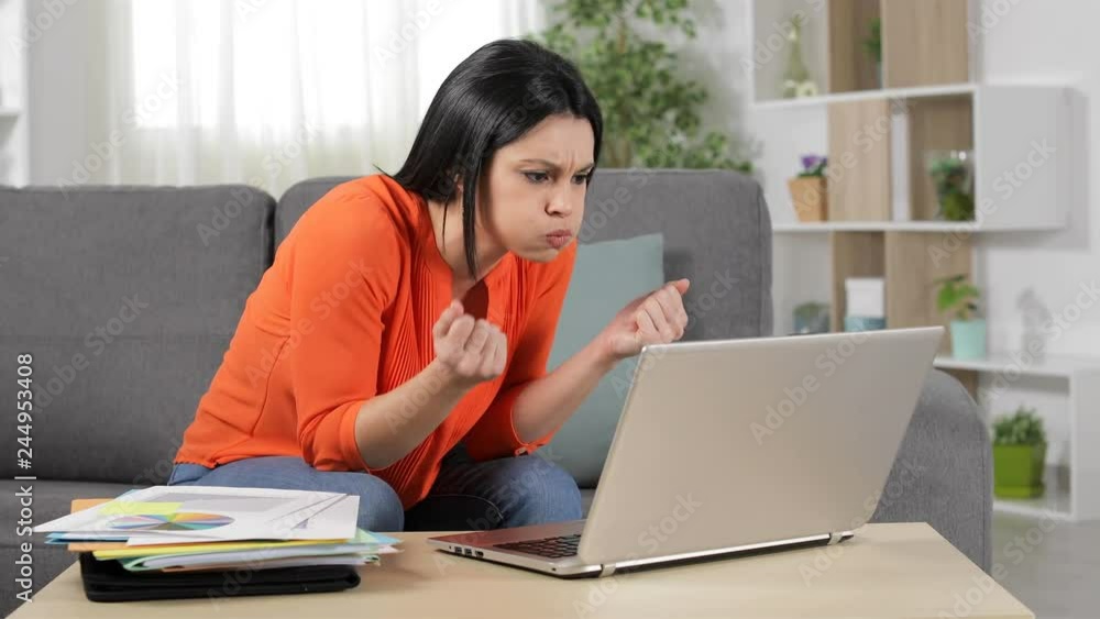 Frustrated self employed working online with a laptop sitting on a couch at home Frustrated self employed working online with a laptop sitting on a couch at home
