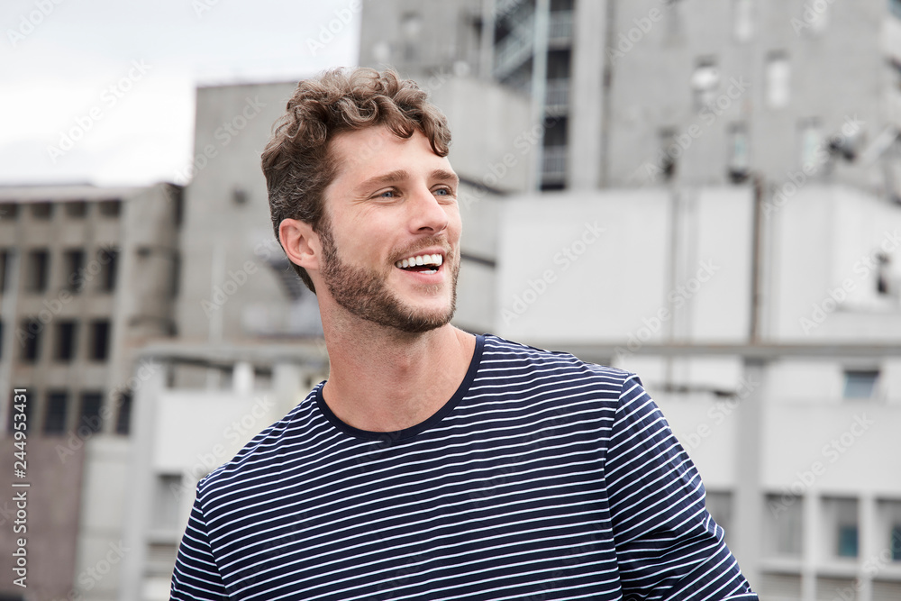 Happy guy in city, smiling and looking away Happy guy in city, smiling and looking away