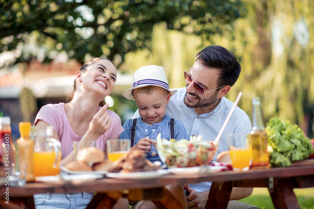 Happy family having barbecue in summer