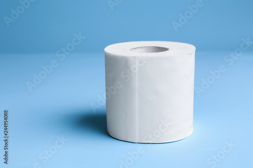 Roll of toilet paper on color background