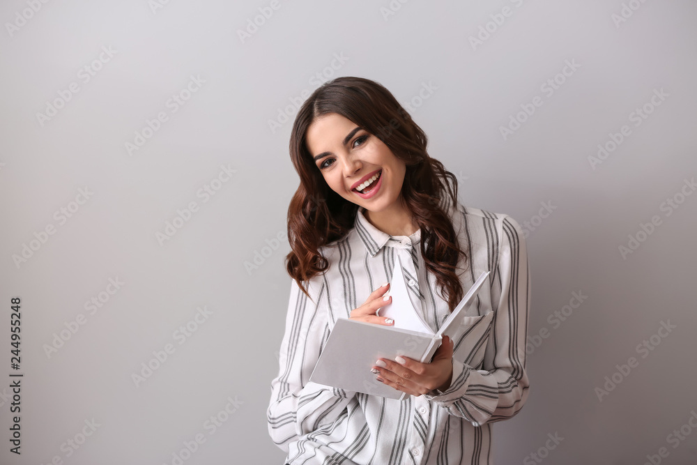 Beautiful young woman with book on light background Beautiful young woman with book on light background
