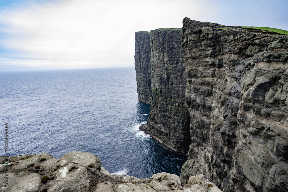 Amazing view of slave mountains of Tralanipan steep cliff in Vagar island, Faroe Islands, Denmark north Atlantic ocean, best destination for hiking, stunning sea stack with deep blue water