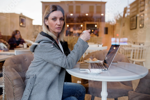 Portrait of businesswoman having coffee while working on laptop in cafe