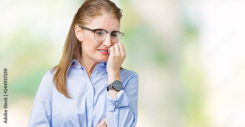 Beautiful middle age mature business woman wearing glasses over isolated background looking stressed and nervous with hands on mouth biting nails. Anxiety problem. Beautiful middle age mature business woman wearing glasses over isolated background looking stressed and nervous with hands on mouth biting nails. Anxiety problem.