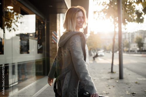 Portrait of smiling woman walking on sidewalk photo