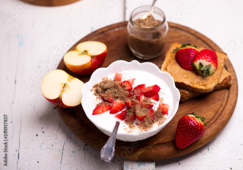 Natural yogurt with strawberries, peanut butter toast and apple. healthy breakfast