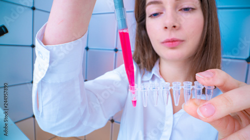 Young woman fill PCR microtubes with dispenser photo