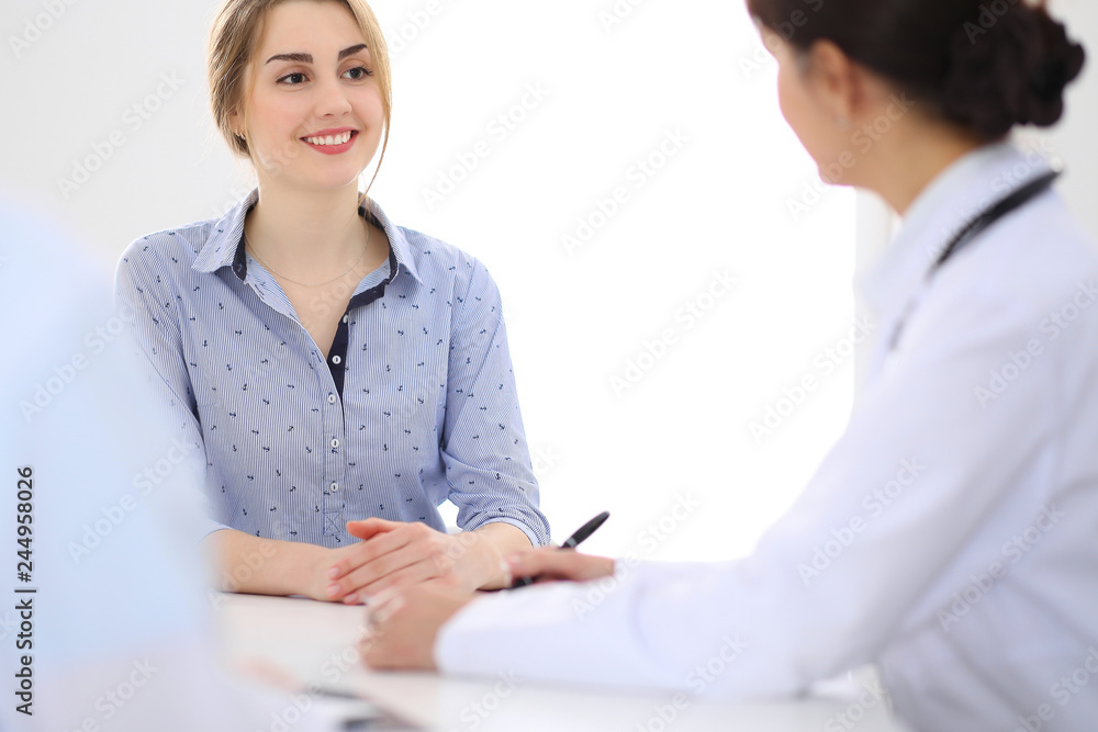 Young woman patient with two cheerful doctors at the background. Young woman patient with two cheerful doctors at the background.
