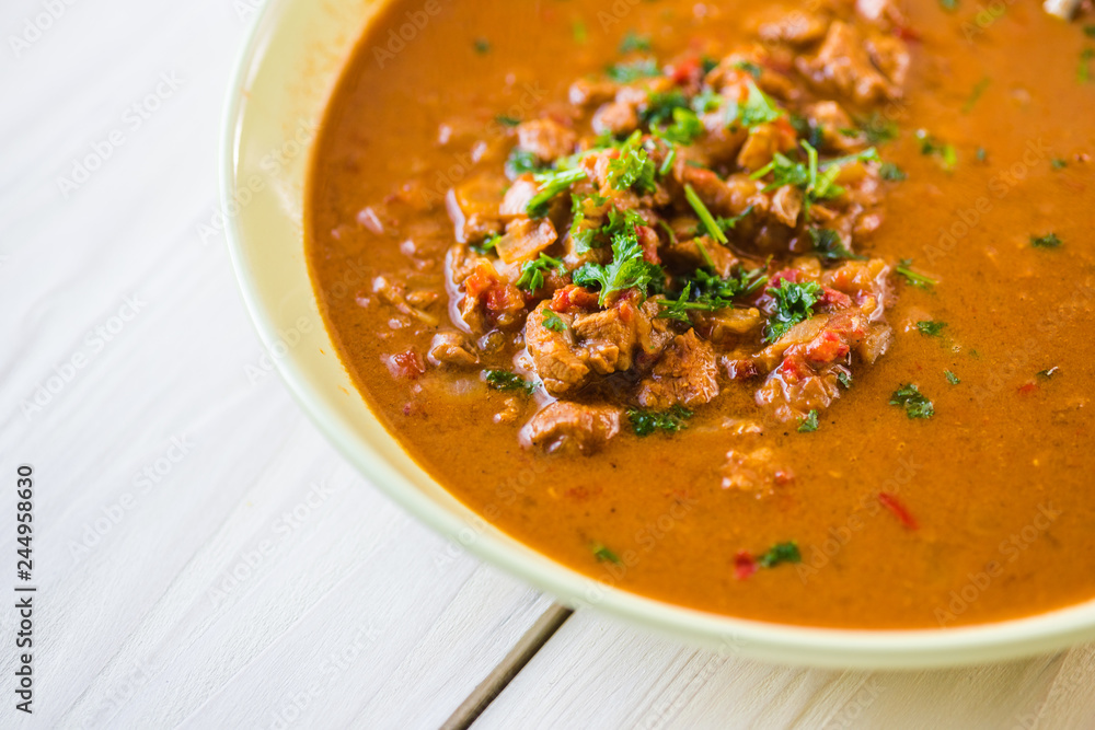 Rindfleischeintopf oder Gulaschsuppe mit Fleischstücken in roter Tomaten sauce