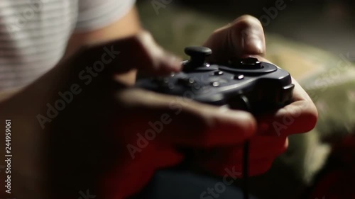 Man holding a black game controller for a video game console photo