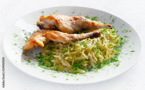 stewed white cabbage decorated with dill and fried rabbit legs  