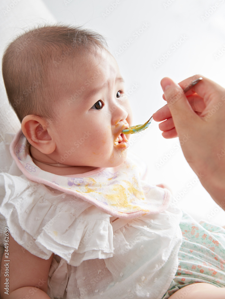 Cute Asian baby being fed