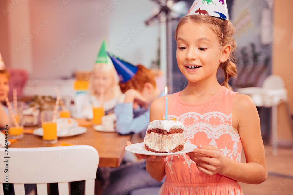 Fototapeta premium Portrait of charming girl that blowing candle