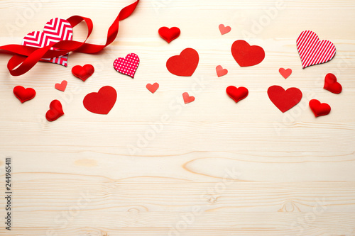 Red hearts with ribbon band on wooden background top vew. Valentines Day. 14 february