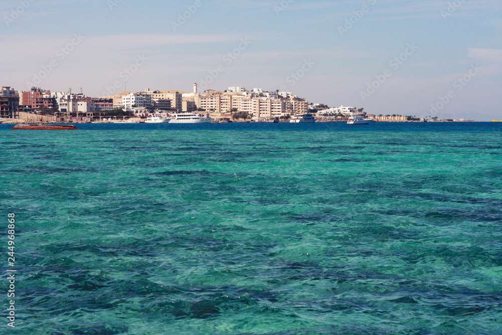 Crystal clear waters of Red Sea, ships and boats and panorama of Hurghada, Egypt