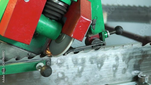 Mechanical machine sharpens saw teeth of woodworking equipment. Grinding wheel sharpening saw blade, makes sparks. Tool repair workshop