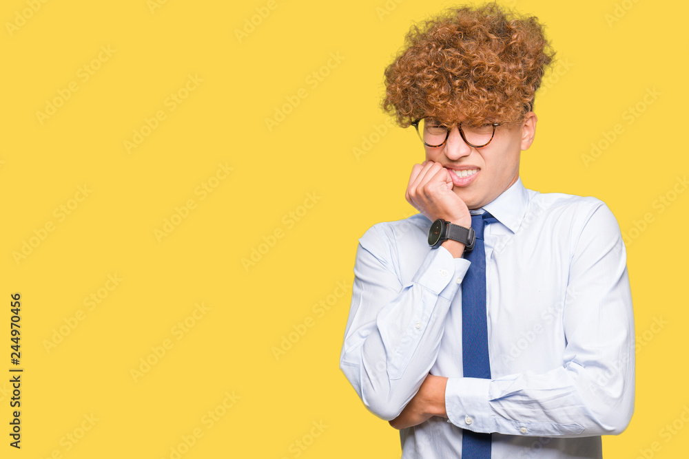 Young handsome business man with afro wearing glasses looking stressed and nervous with hands on mouth biting nails. Anxiety problem. Young handsome business man with afro wearing glasses looking stressed and nervous with hands on mouth biting nails. Anxiety problem.