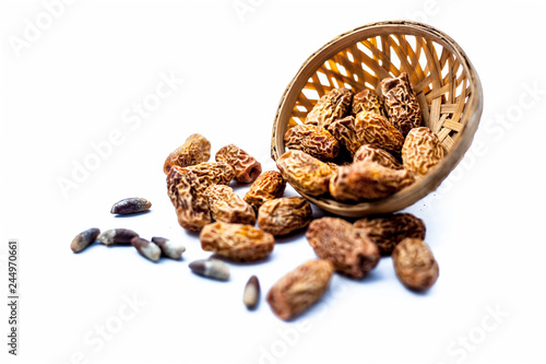 Close up shot of raw dried dates or kharek or sukhi khajoor or Phoenix dactylifera  in a hamper isolated on white. photo