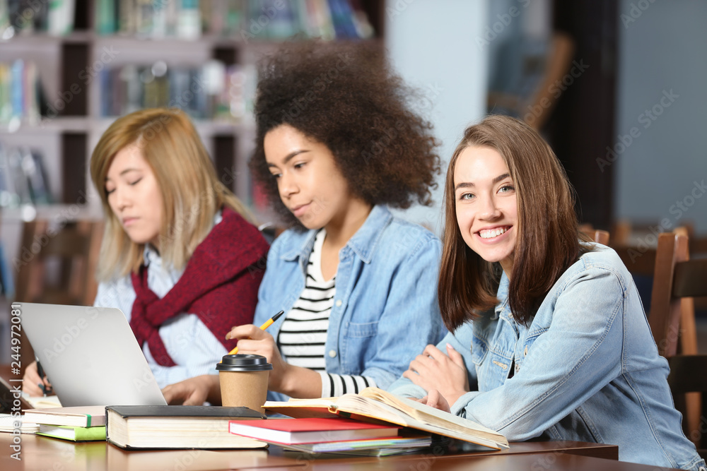 Group of students studying at table in library Group of students studying at table in library