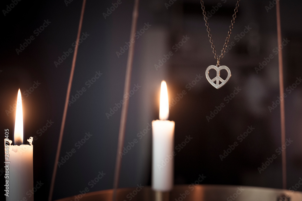 Peace heart symbol necklace and candles glowing on advent chandelier. Peace heart symbol necklace and candles glowing on advent chandelier.